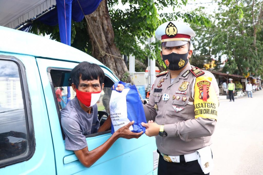 Kasat Lantas Polres Karimun, AKP R Moch Dwi Ramadhanto membagikan paket sembako pada salah satu sopir oplet 