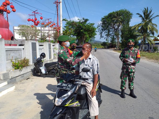 
 Babinsa Koramil 04/TBG Bagi Masker Depan Kelenteng, Jaga Protokol Kesehatan Saat Perayaan Imlek