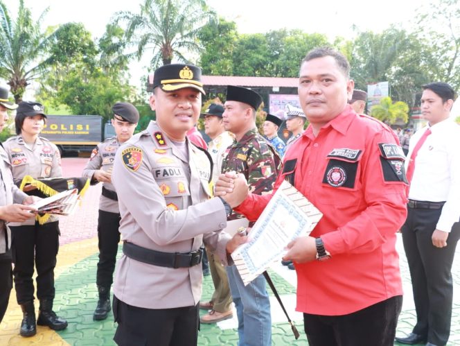 
 Kapolres Karimun, AKBP Fadli Agus salam komando dengan wakil ketua ormas Pemuda Batak Bersatu, Maszan Sianturi usai memberikan reward