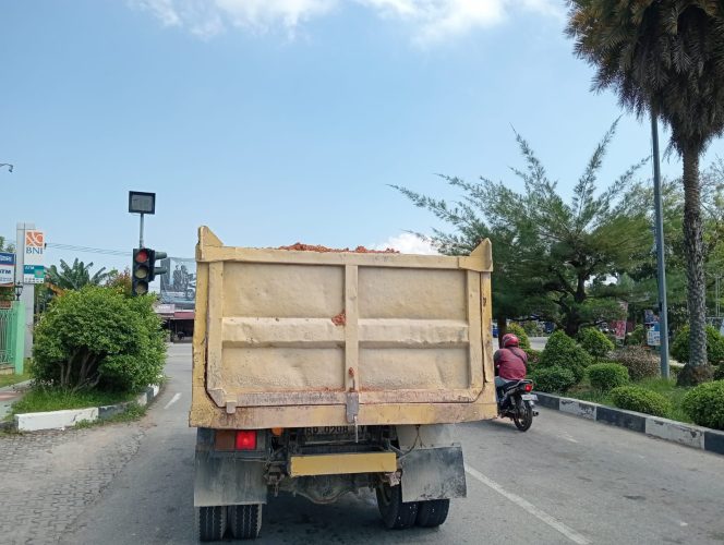 
 Truck pengangkut galian c (tanah urug) terlihat tak menggunakan penutup saat membawa muatan tanah melintas di jalan raya 